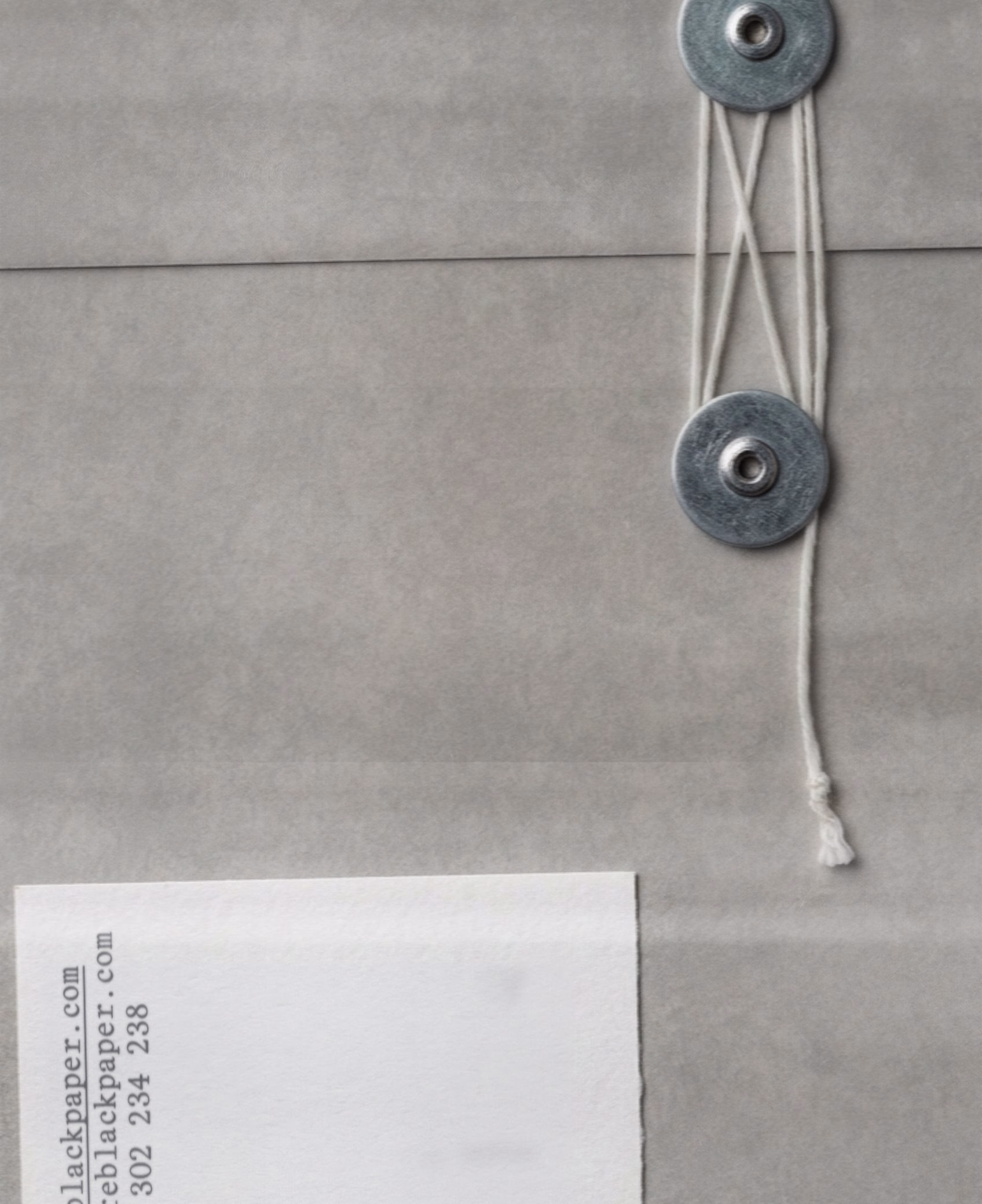 Black Paper grey envelope with string-and-washer closure and typewriter address label, DOMINGO. print house identity