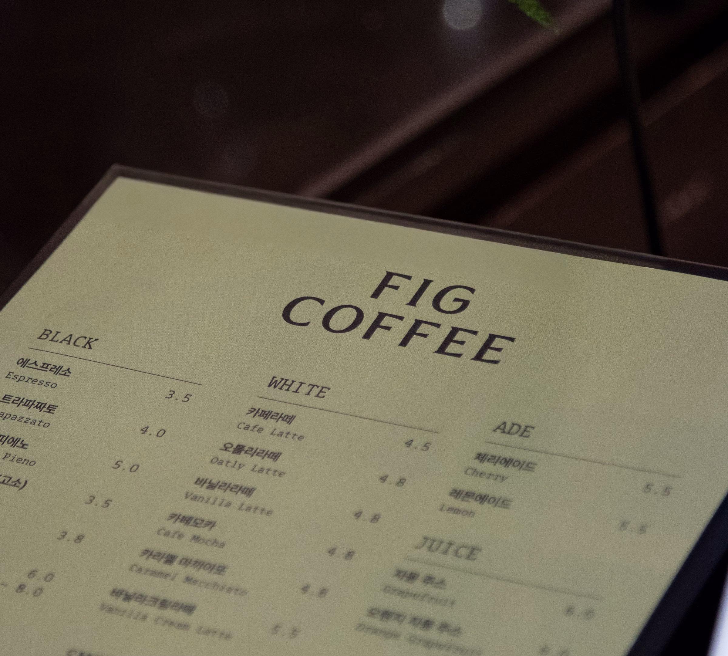 A green menu featuring "FIG COFFEE" in bold typography, listing coffee and juice options with prices.