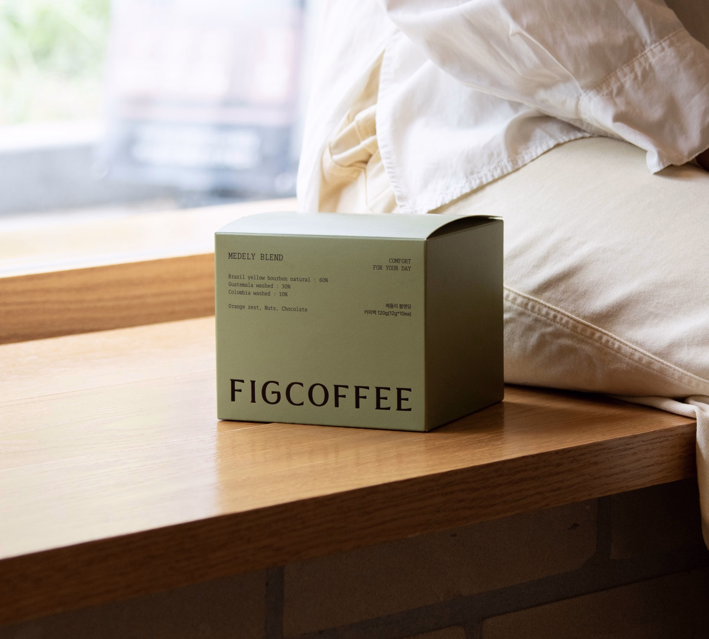 Green FIGCOFFEE box on a wooden table, coffee gift packaging by Junyoup Bong