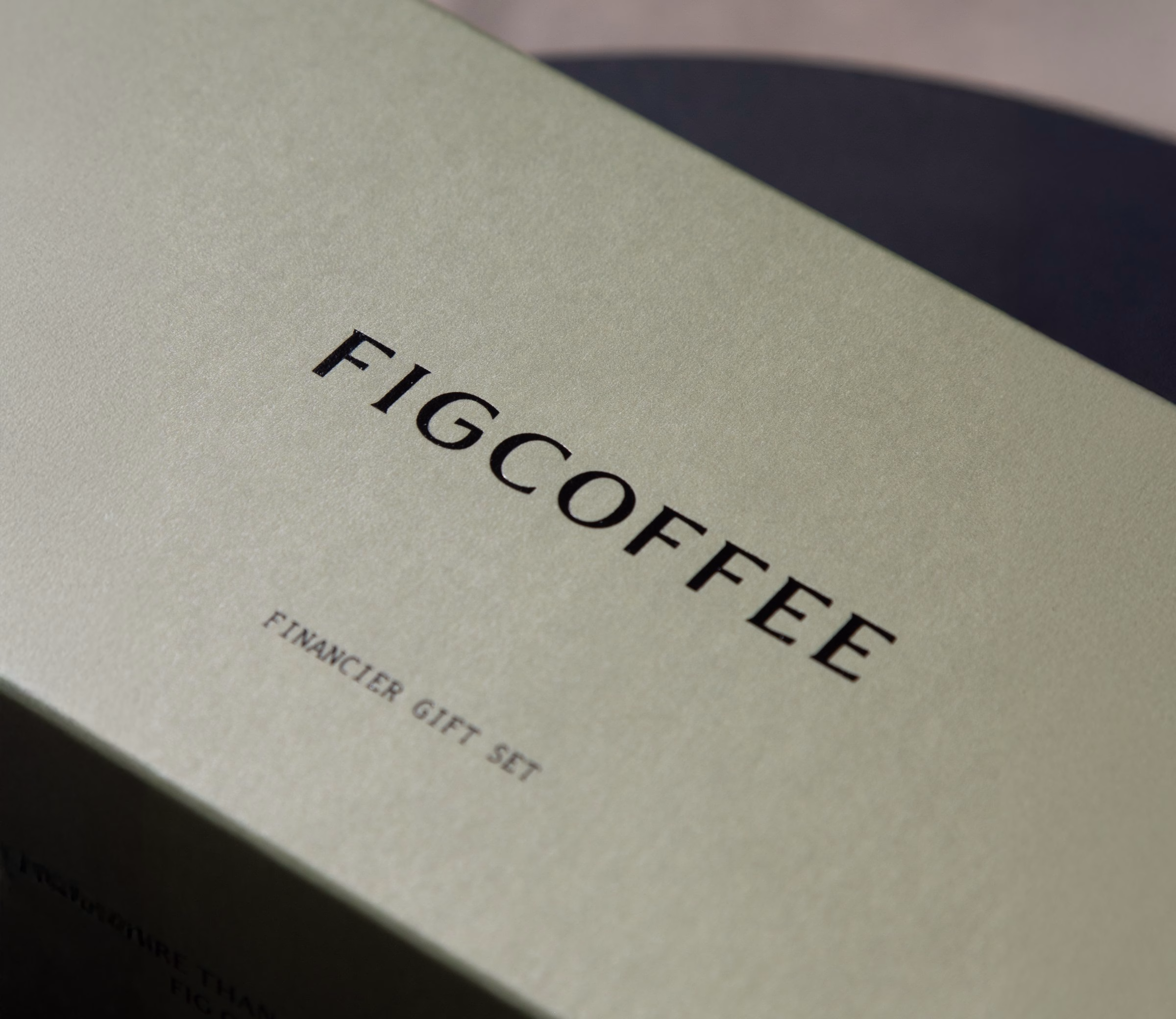 Close-up of the FIGCOFFEE wordmark on a pale green box lid