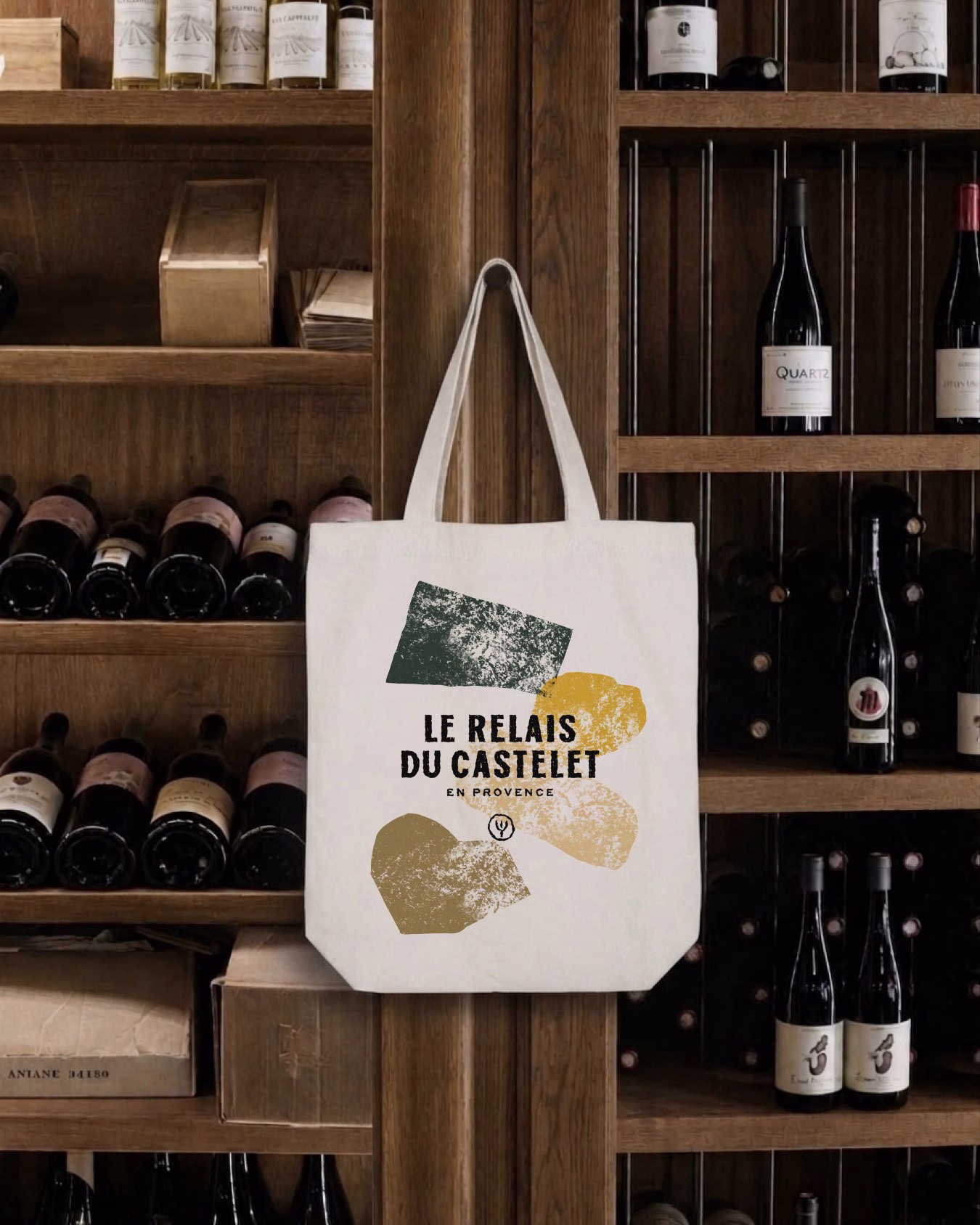 A canvas tote bag displaying the hand-drawn typography and earthy colors for Le Relais du Castelet brand identity.